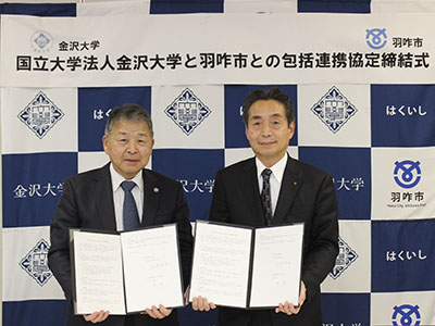包括連携協定書を手にする山崎光悦金沢大学長（左）と岸博一羽咋市長（右）